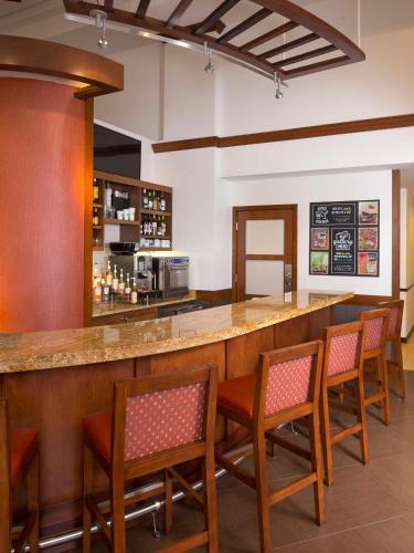 a bar in a restaurant with chairs and a counter at Hyatt Place Dallas/Plano in Plano