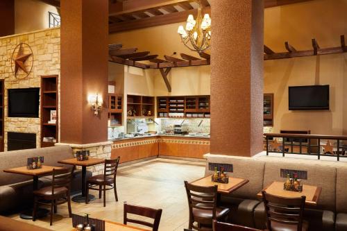 a restaurant with tables and chairs and a bar at Hyatt Place Fort Worth Stockyard in Fort Worth