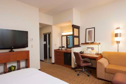 a hotel room with a bed and a desk with a computer at Hyatt Place Des Moines Downtown in Des Moines