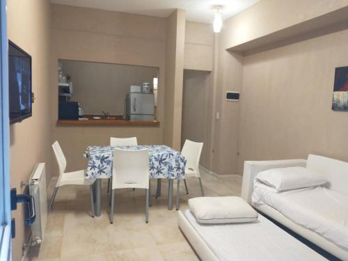 een eetkamer met een tafel en witte stoelen bij Departamento Divino a tres cuadras de la playa. in Carilo