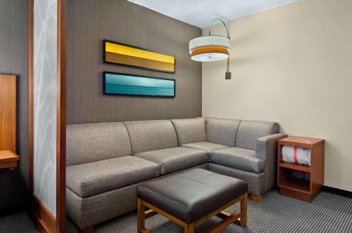 a living room with a couch and a table at Hyatt Place Fredericksburg at Mary Washington in Fredericksburg