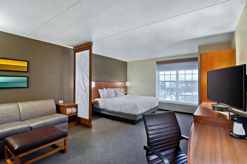 een hotelkamer met een bed en een televisie bij Hyatt Place Fredericksburg at Mary Washington in Fredericksburg