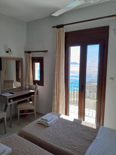 1 dormitorio con 2 camas, escritorio y ventana en Kavos Melissa Studios, en Agios Pavlos