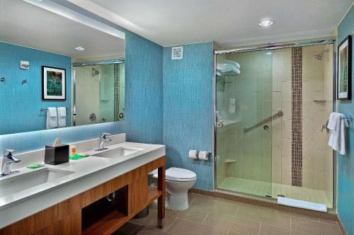 a bathroom with a shower and a sink and a toilet at Hyatt Place Fredericksburg at Mary Washington in Fredericksburg