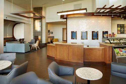 a lobby with a waiting area with tables and chairs at Hyatt Place Grand Rapids South in Wyoming