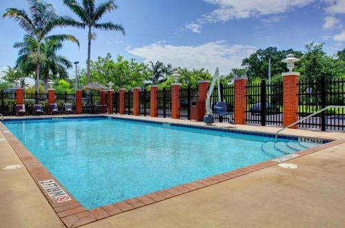 a swimming pool at a resort with a fence at Hyatt Place Fort Lauderdale Airport/Cruise Port in Dania Beach