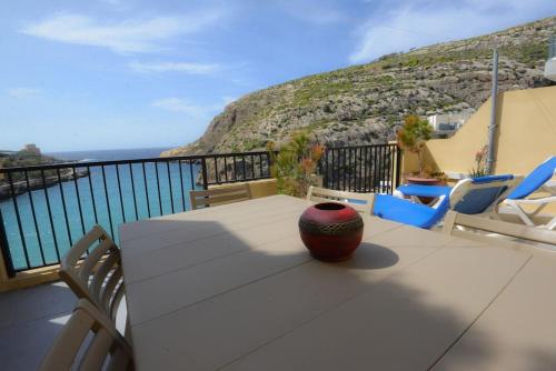 a table with a vase sitting on top of a balcony at Seafront duplex Penthouse with Terrace overlooking Xlendi Bay in Xlendi