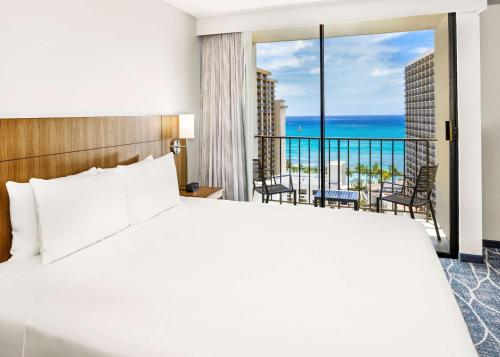 a bedroom with a bed and a view of the ocean at Hyatt Place Waikiki Beach in Honolulu