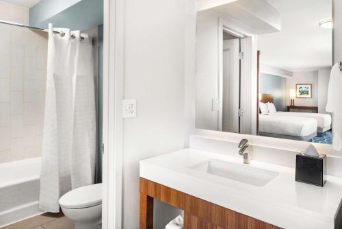 a bathroom with a sink and a toilet and a mirror at Hyatt Place Waikiki Beach in Honolulu