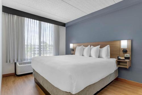 ein großes Bett in einem Hotelzimmer mit einem großen Fenster in der Unterkunft Hyatt Place Houston-North in Houston
