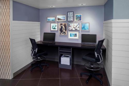 an office with two computers on a desk with two chairs at Hyatt Place Long Island East End in Riverhead