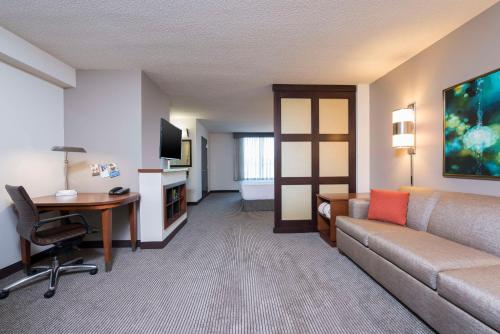 a hotel room with a couch and a desk and a computer at Hyatt Place Lexington in Lexington