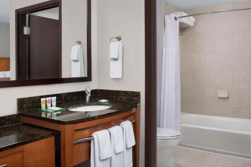 a bathroom with a sink and a toilet and a tub at Hyatt Place Sugar Land in Sugar Land