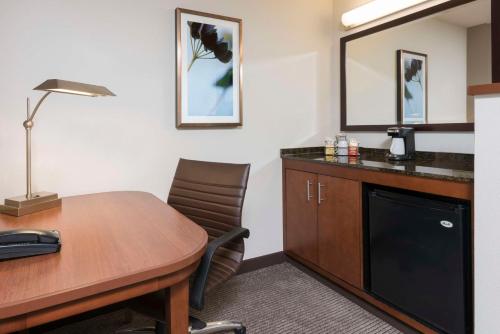 um quarto com uma secretária, uma mesa e um candeeiro em Hyatt Place Lexington em Lexington