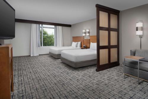 um quarto de hotel com duas camas e uma televisão em Hyatt Place Sugar Land em Sugar Land