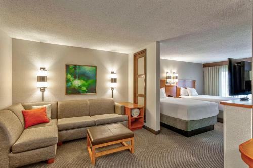 a hotel room with a couch and a bed at Hyatt Place Kansas City/Overland Park/Convention Center in Overland Park