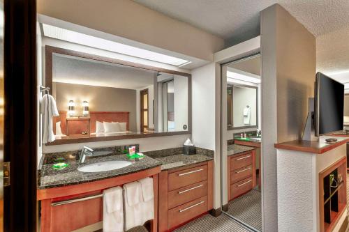 a bathroom with a sink and a large mirror at Hyatt Place Kansas City/Overland Park/Convention Center in Overland Park