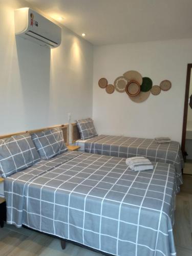 two beds in a room with a blue bedspread at Pousada Solarium in Canoa Quebrada