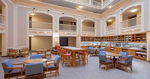 uma biblioteca com mesas, cadeiras e livros em Hyatt Place New Orleans Convention Center em Nova Orleans