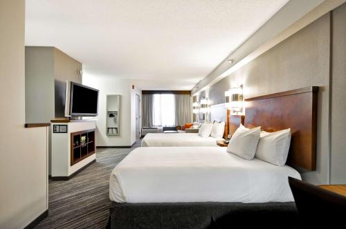 a hotel room with two beds and a flat screen tv at Hyatt Place Minneapolis Eden Prairie in Eden Prairie