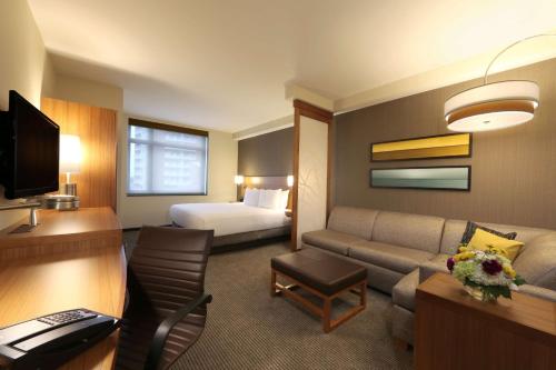 a hotel room with a couch and a bed at Hyatt Place Flushing/LGA Airport in Queens