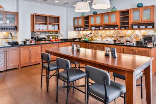 a large kitchen with a wooden table and chairs at Hyatt Place Chesapeake in Chesapeake