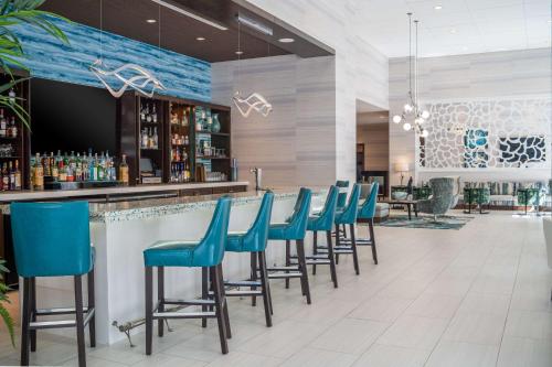 a bar with blue bar stools in a restaurant at Hyatt Place West Palm Beach in West Palm Beach