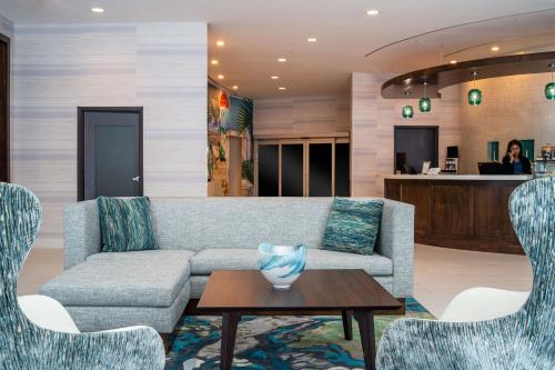 a living room with a couch and chairs and a table at Hyatt Place West Palm Beach in West Palm Beach