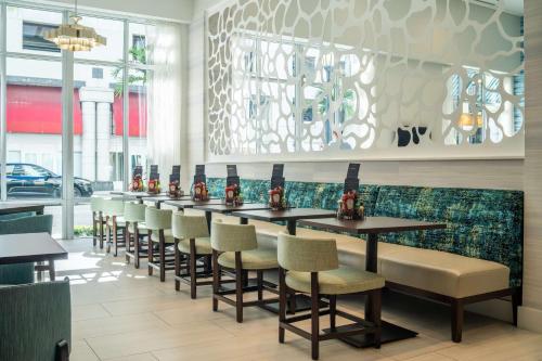 a row of tables and chairs in a restaurant at Hyatt Place West Palm Beach in West Palm Beach