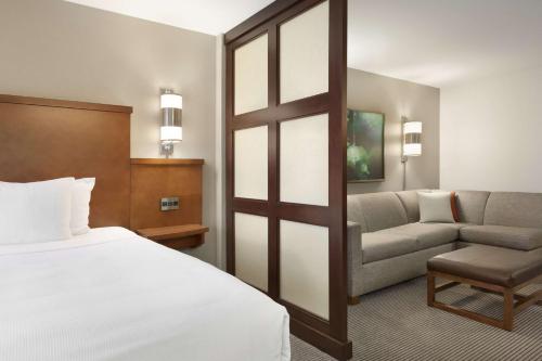 a hotel room with a bed and a couch at Hyatt Place Portland Airport/Cascade Station in Portland