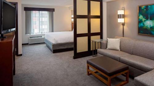 um quarto de hotel com um sofá e uma cama em Hyatt Place Pittsburgh North Shore em Pittsburgh