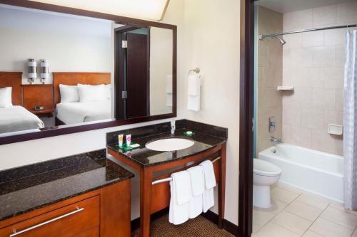 a bathroom with a sink and a toilet and a mirror at Hyatt Place Phoenix/ Mesa in Mesa