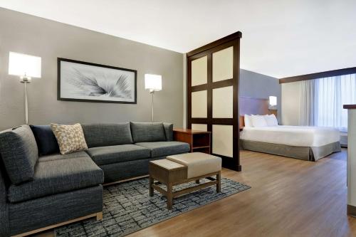 a living room with a couch and a bed at Hyatt Place San Antonio North Stone Oak in San Antonio