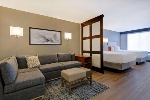 Habitación de hotel con sofá y cama en Hyatt Place San Antonio North Stone Oak en San Antonio