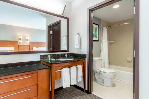 a bathroom with a sink and a toilet and a mirror at Hyatt Place Salt Lake City Airport in Salt Lake City