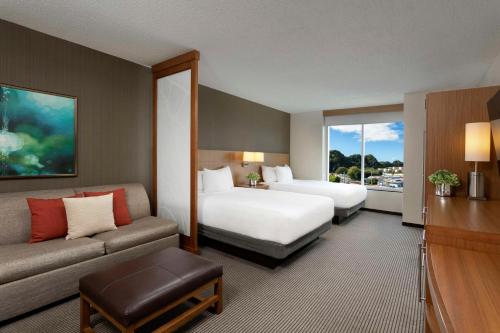 a hotel room with two beds and a couch at Hyatt Place Bayamon in Bayamón