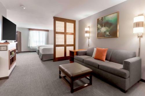 a hotel room with a couch and a bed at Hyatt Place Salt Lake City Airport in Salt Lake City