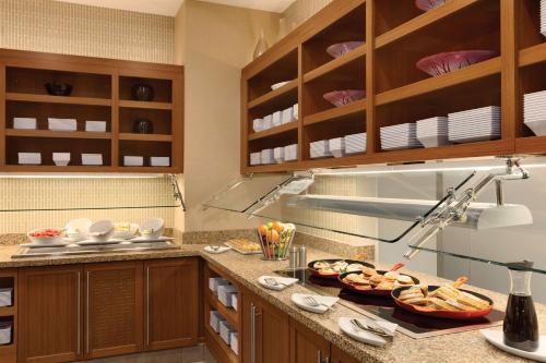 a kitchen with wooden cabinets and food on a counter at Hyatt Place St. Louis/Chesterfield in Chesterfield