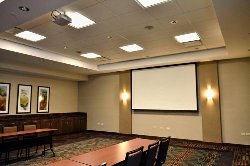 a large room with tables and chairs and a projection screen at Hyatt Place Manati in Manati