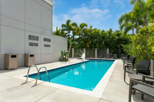 a swimming pool with chairs next to a building at Hyatt Place Manati in Manati