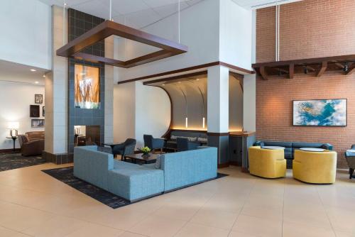 a lobby with a blue couch and yellow chairs at Hyatt Place Sarasota/Bradenton in Sarasota