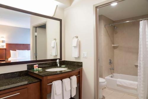 a bathroom with a sink and a toilet and a mirror at Hyatt Place Sarasota/Bradenton in Sarasota