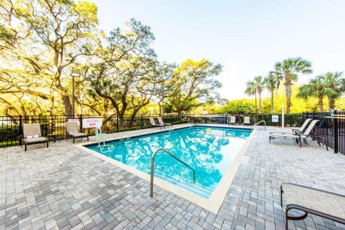 a swimming pool with two chairs and a fence at Hyatt Place Tampa Busch Gardens in Tampa