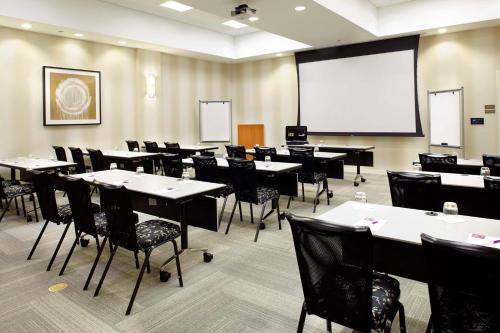 einen Konferenzraum mit Tischen, Stühlen und einem Whiteboard in der Unterkunft Hyatt Place Miami Airport East in Miami