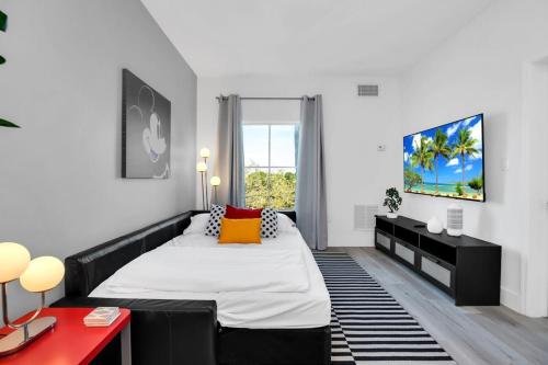 1 dormitorio con 1 cama y TV en la pared en NEW in Lake Buena Vista 1 mile to Disney Springs, en Orlando