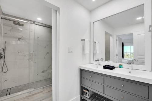 La salle de bains est pourvue d'une douche, d'un lavabo et d'un miroir. dans l'établissement NEW in Lake Buena Vista 1 mile to Disney Springs, à Orlando