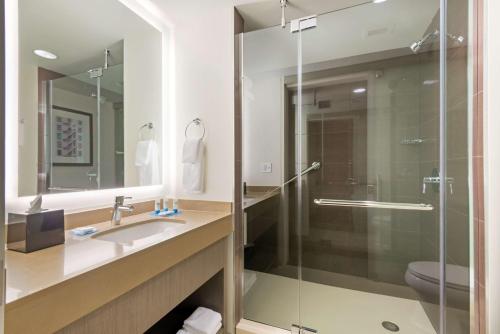 a bathroom with a sink and a glass shower at Hyatt House Denver/Downtown in Denver
