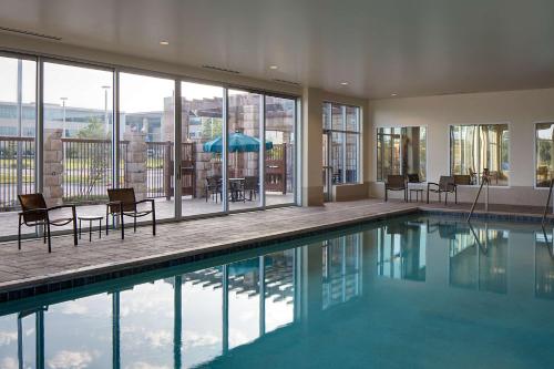 a swimming pool with chairs and a table in a house at Hyatt Place DFW in Irving