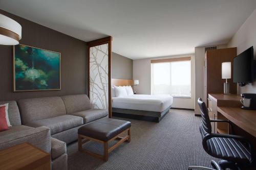 een hotelkamer met een bank en een bed bij Hyatt Place DFW in Irving