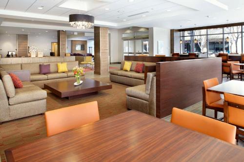 un soggiorno con divani, tavoli e sedie di Hyatt House Denver Lakewood Belmar a Lakewood